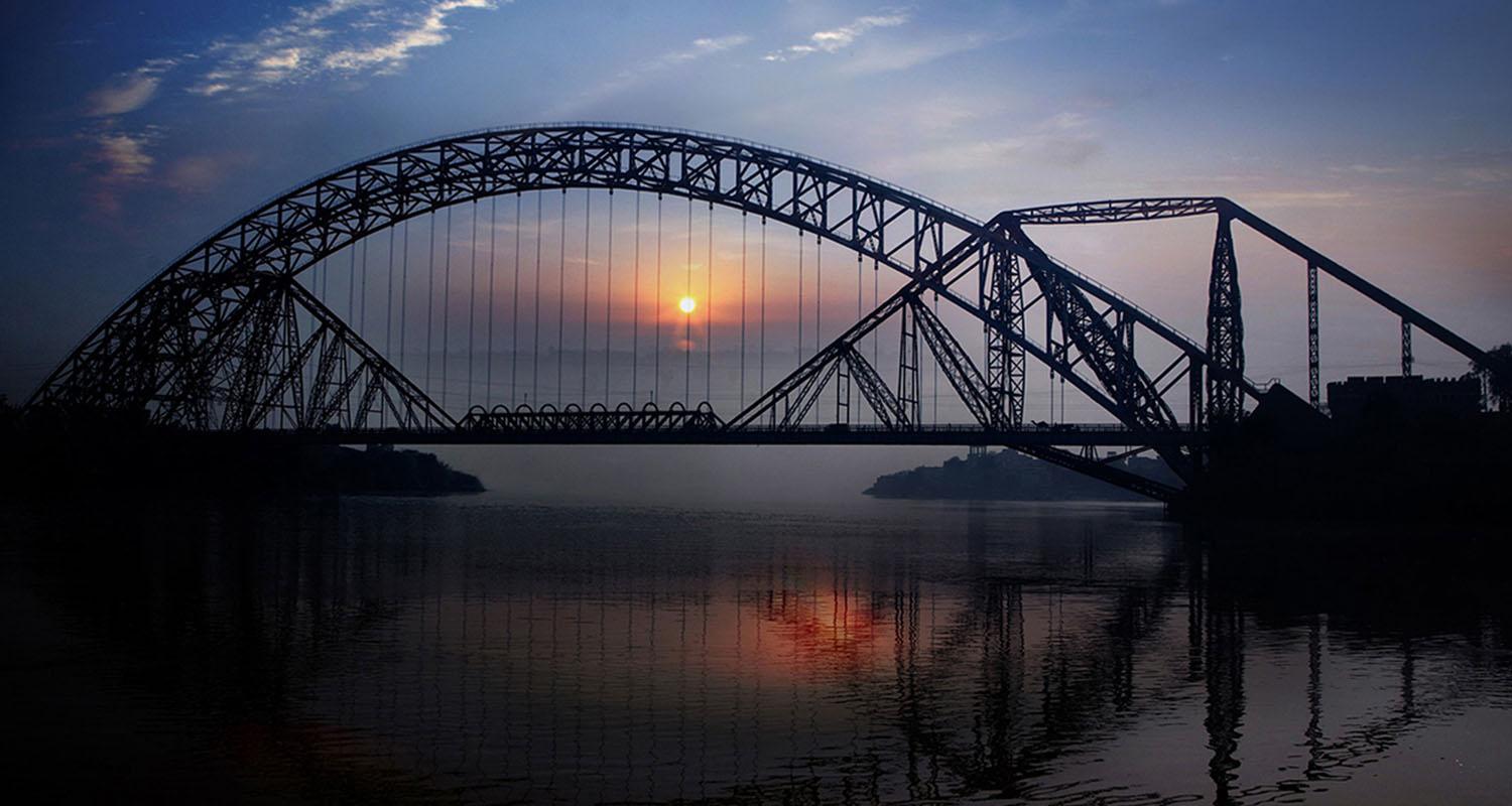 A serene view of Shangrila Resort Skardu with its iconic red-roof cottages, reflected in the crystal-clear waters of Lower Kachura Lake surrounded by snow-capped mountains.”
